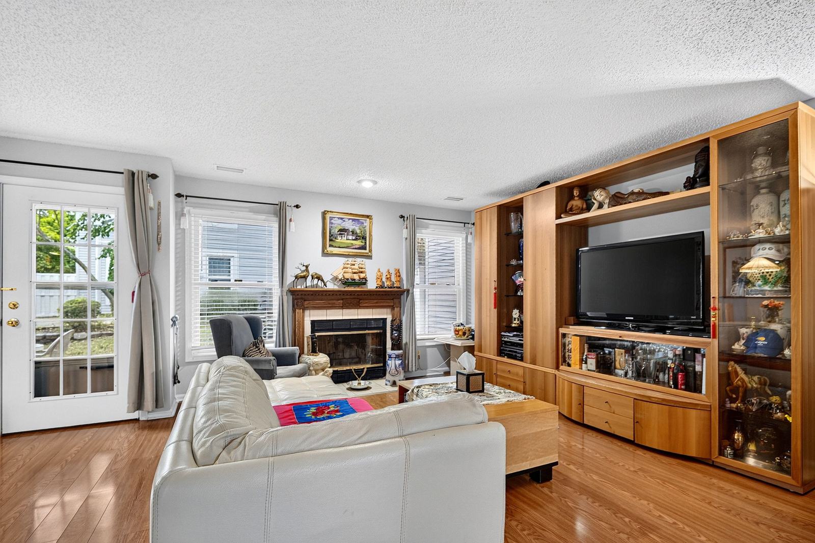 Wood-burning fireplace with a wood mantel, beside the glass-paned door to the patio