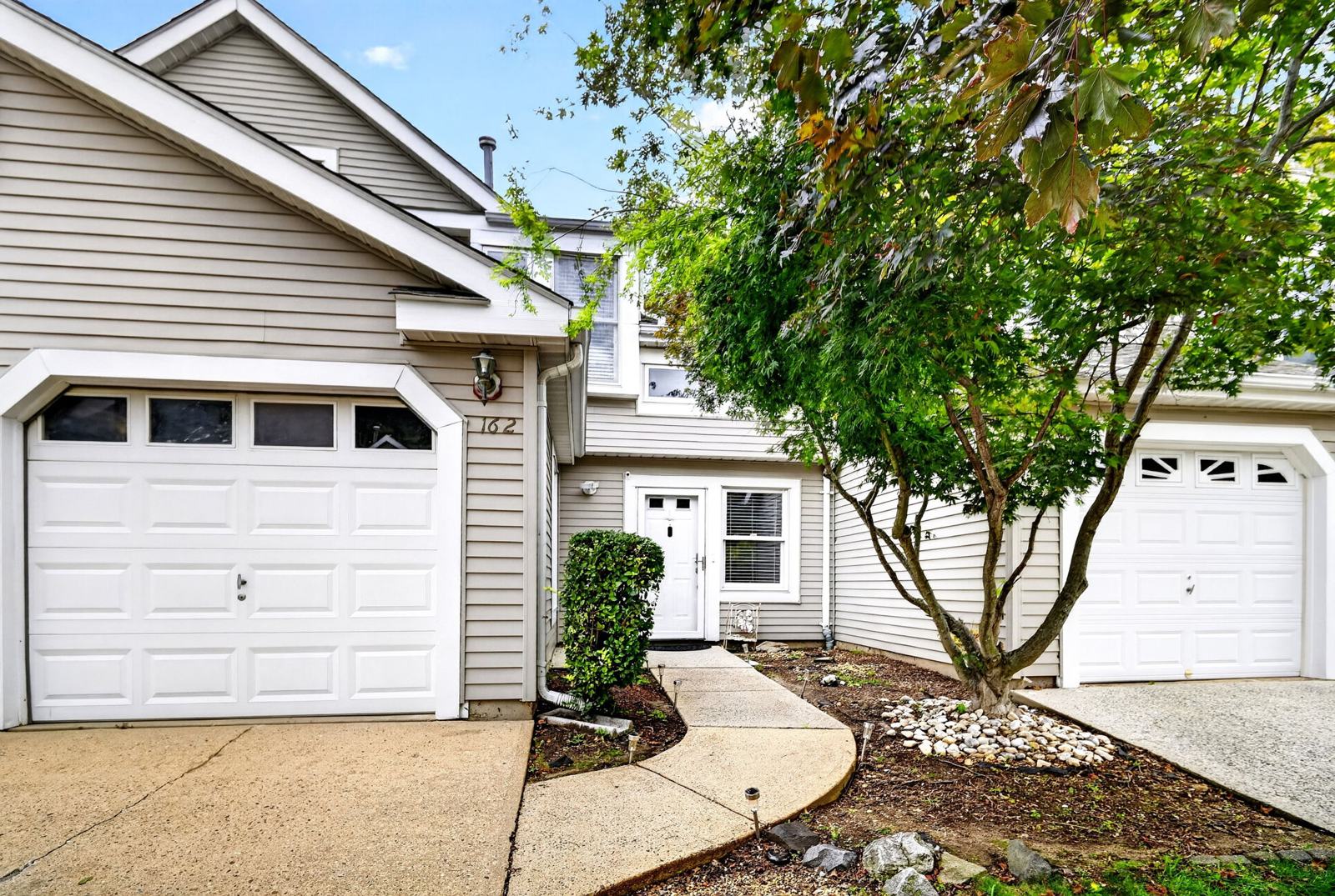 Front of 162 Stults Lane, a two-story townhome in Fox Meadow, East Brunswick NJ, with its attached 1-car garage